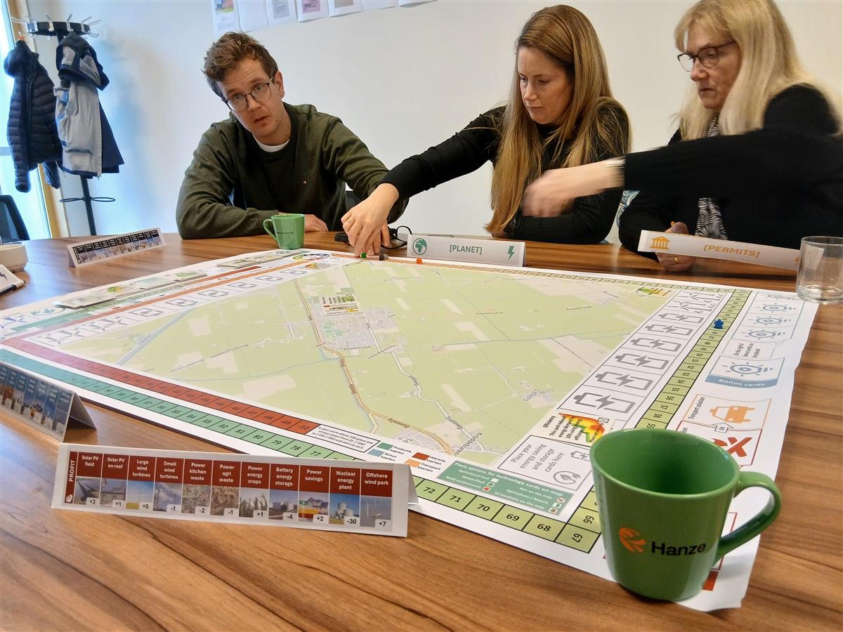 tre personer spiller et brettspill - Klikk for stort bilde